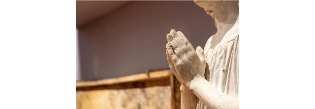 A marble statue’s hands joined in prayer